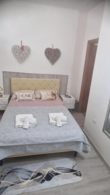 1 dormitorio con 1 cama con corazones en la pared en Casa Nicole, en Assemini