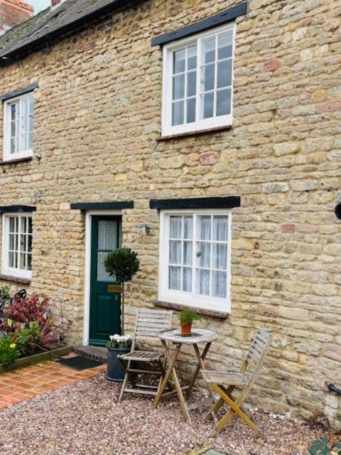 a table and two chairs in front of a brick building at NEW Stylish Cosy Dog Friendly Cottage Parking Central in Oundle