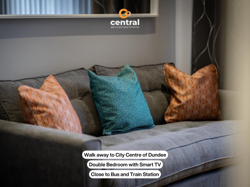 ein Sofa mit vier Kissen darauf und einem Schild daran in der Unterkunft Trades Lane by CENTRAL SERVICED APARTMENTS - Cosy 1 Bedroom - Central Location - Walk Away from Waterfront - Walk Away to Bus & Train Station - Long Stays Welcome in Dundee