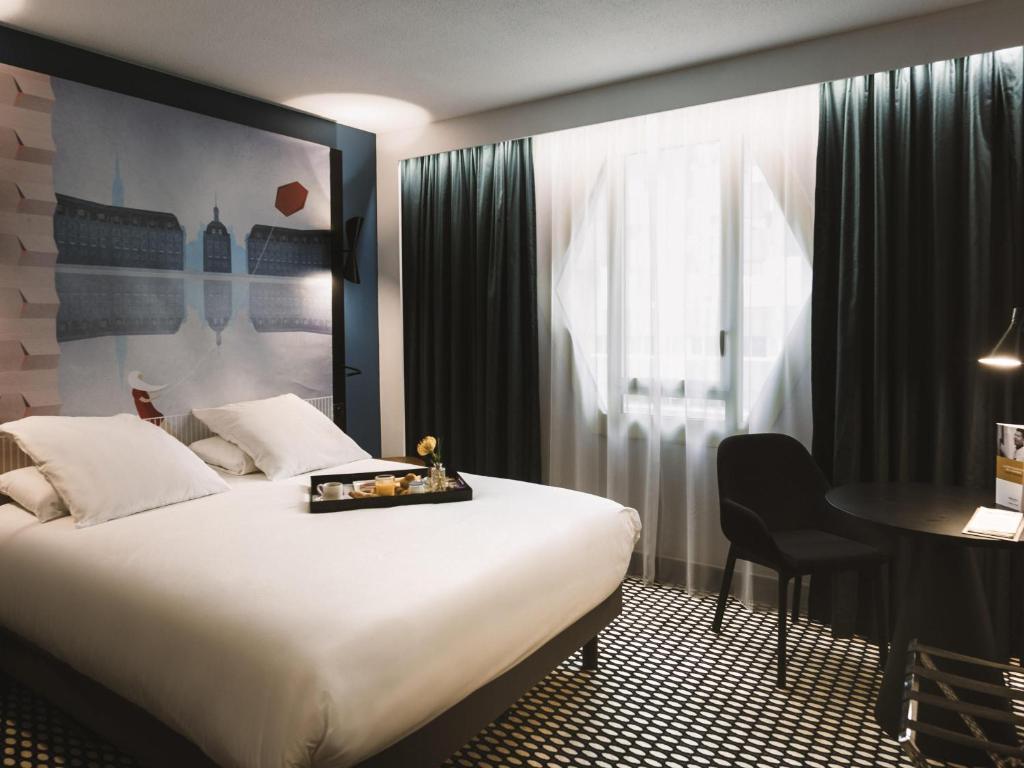 Mercure Bordeaux Centre Ville في بوردو: غرفة فندقية بها سرير كبير ومكتب