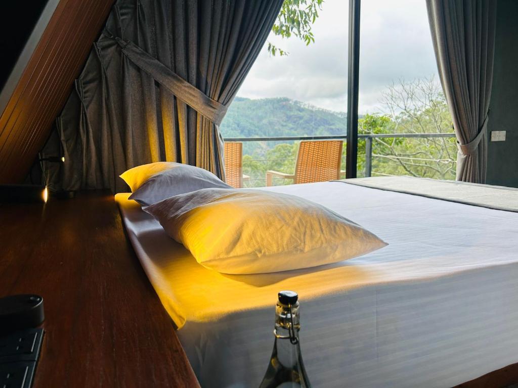 une chambre avec un lit avec une grande fenêtre dans l'établissement Camellia Lodge Ella, à Ella