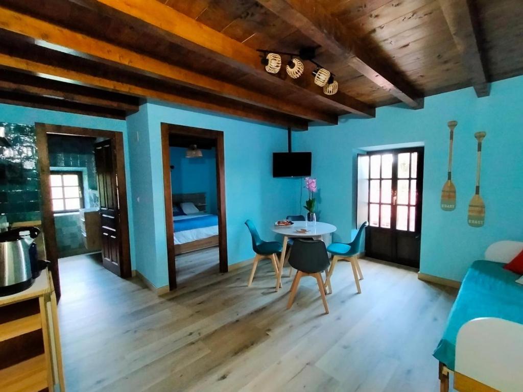 a living room with blue walls and a table and chairs at Urdaibai alojamientos en reserva de la biosfera in Isla Becoa