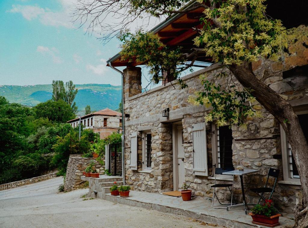 a stone house with a table and chairs outside at Bridge View Cottage in Podhokhórion