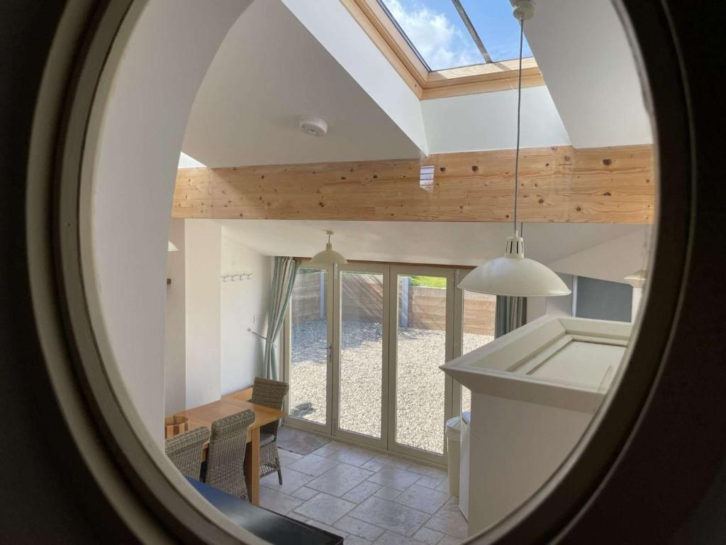 una vista della soffitta di una cucina e sala da pranzo con una finestra di WELL COTTAGE - Salthouse a Salthouse