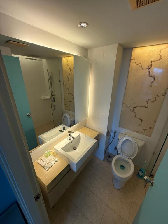 une salle de bain avec un lavabo, des toilettes et un miroir dans l'établissement Atlantis Condo Resort GP, à Jomtien Beach