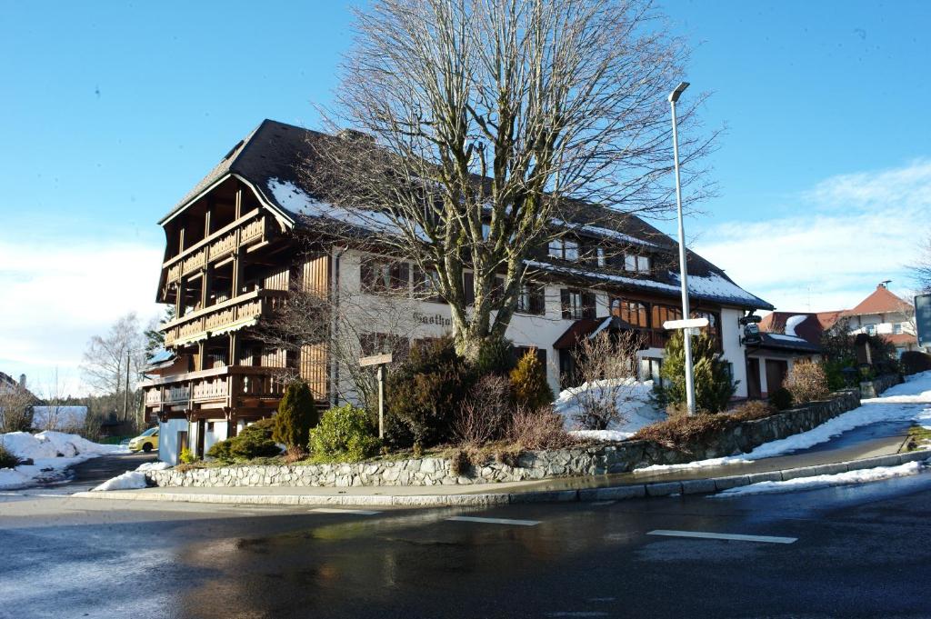 une maison sur le côté d'une rue avec un arbre dans l'établissement Höhengasthof Rössle, à Schluchsee