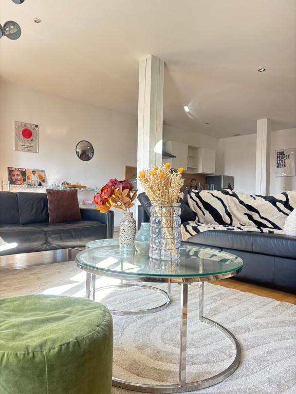 a living room with a glass table with flowers on it at Suite Aubenas centre - château in Aubenas