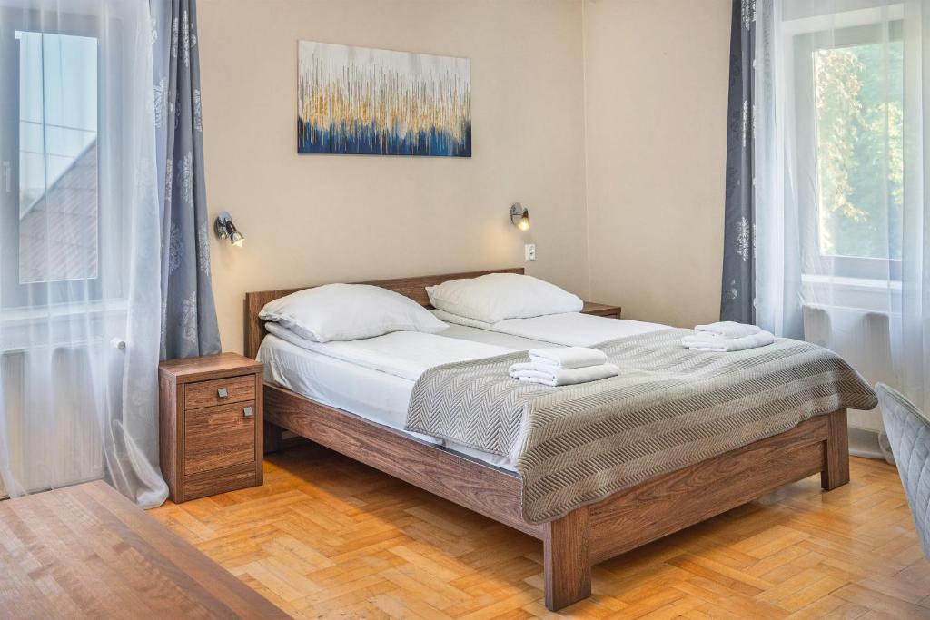 una camera da letto con un letto con lenzuola e cuscini bianchi di Royal Rooms a Danzica
