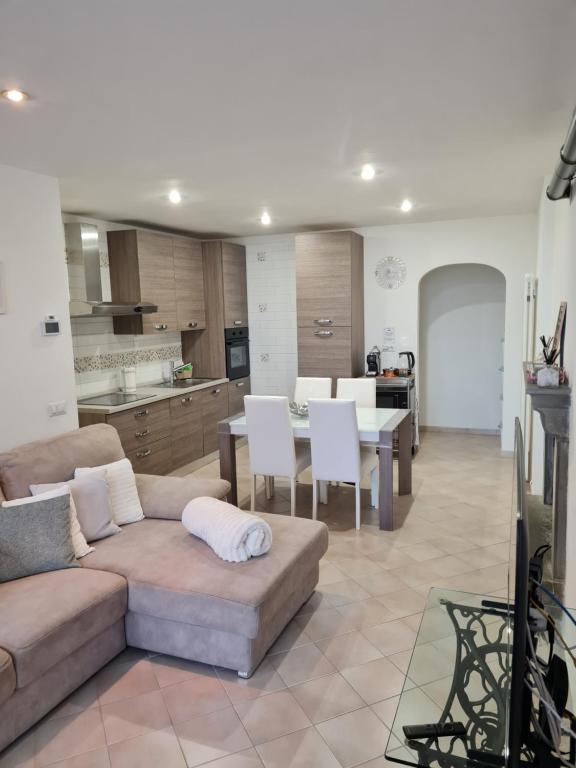 a living room with a couch and a table and a kitchen at Casa vacanze Castello in Frontone