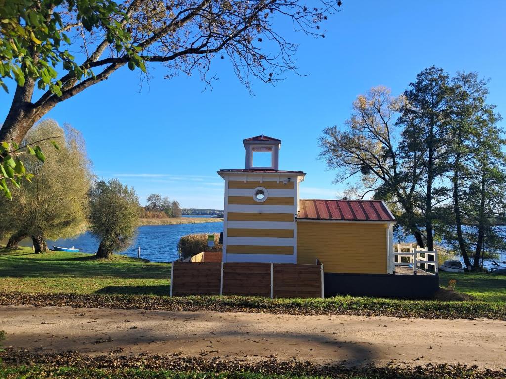 a lighthouse on the side of a body of water at Mazurska Latarnia na prywatnej plaży tuż przy linii brzegowej pomost stawy gospodarstwo pasieka in Rydzówka