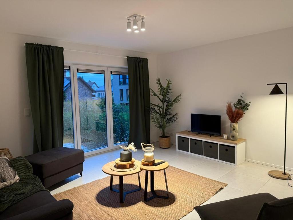 a living room with a couch and a tv at Frangines & Compagnie in Hotton