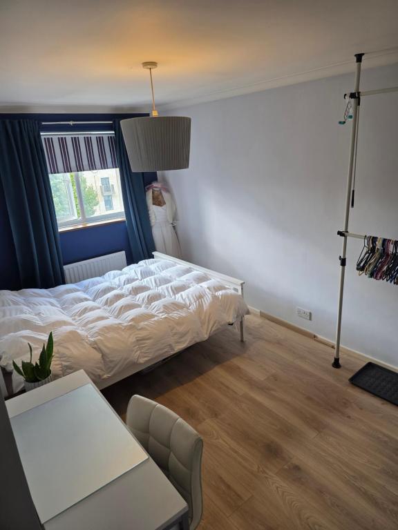 una camera da letto con un letto, un tavolo e una finestra di Spacious rooms Golders Green NW2 a Londra