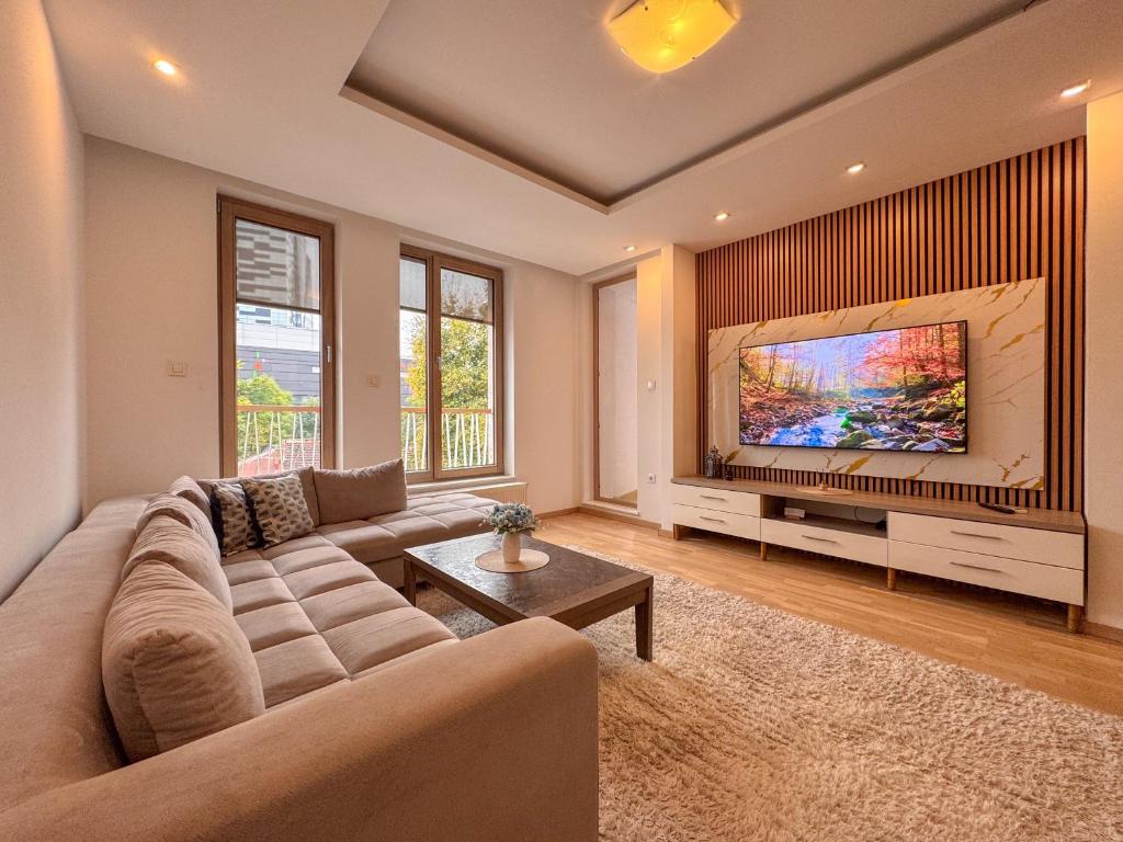 a large living room with a couch and a tv at Luxury apartment 304 - next to Sarajevo City Center in Sarajevo