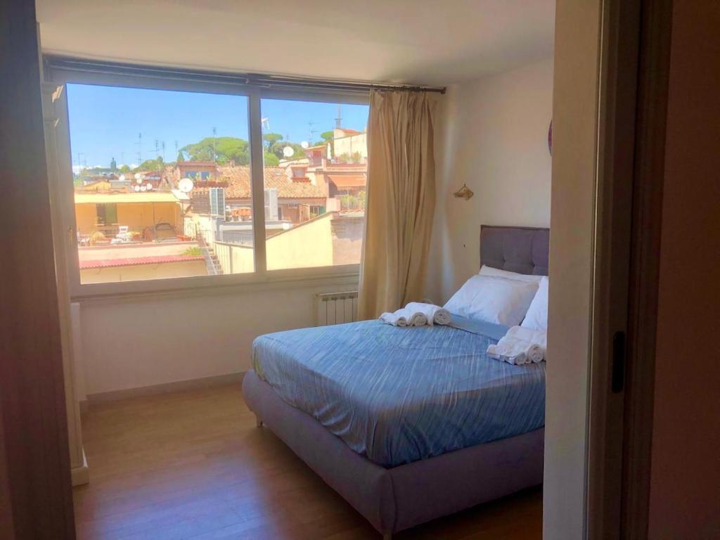 a bedroom with a bed and a large window at Private terrace penthouse with elevator Piazza Spagna in Rome