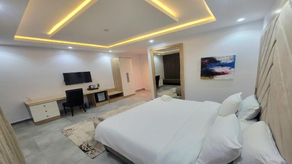 Un dormitorio con cama, escritorio y televisión. en Yetunde Ajayi Airport Hotel, en Lagos