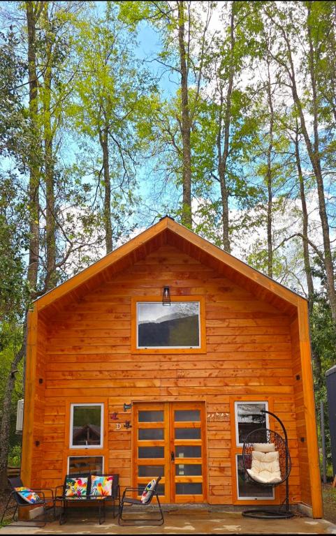 a log cabin with two windows and a porch at Nordica D in Coñaripe