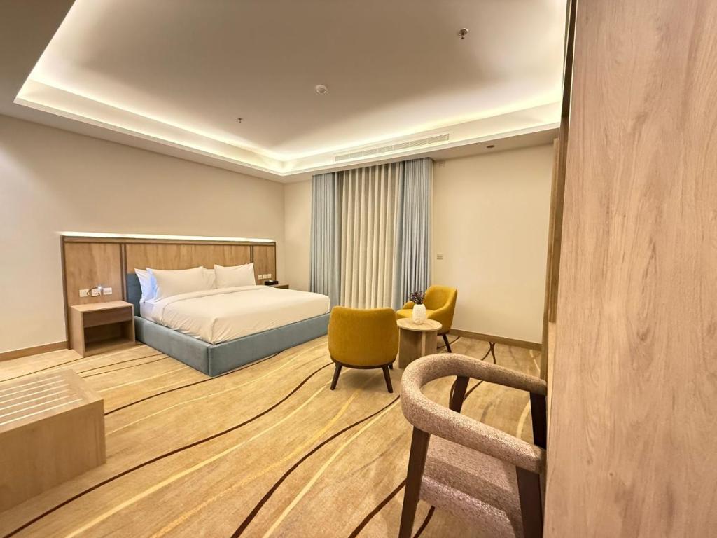 a hotel room with a bed and a chair at فندق أثير بارك in Jazan