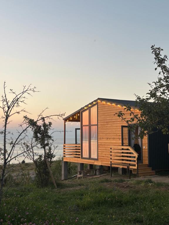 Una pequeña casa de madera con un banco en un campo. en Jargylchak-Sunrise, en Kichi-Jargylchak