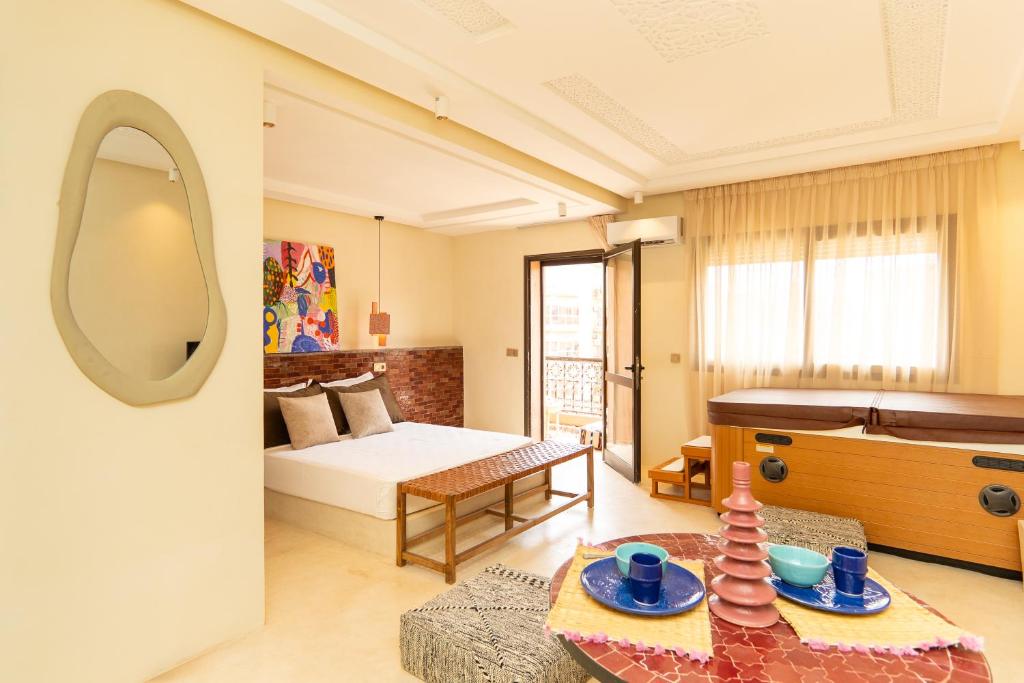 een kamer met een bed en een tafel met een spiegel bij Excellent apartment plus hot tub in Marrakesh