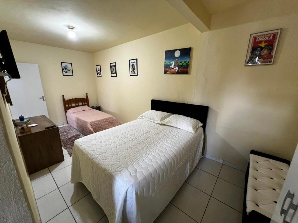 a bedroom with a bed and a dresser in it at Casa & Conforto in Londrina