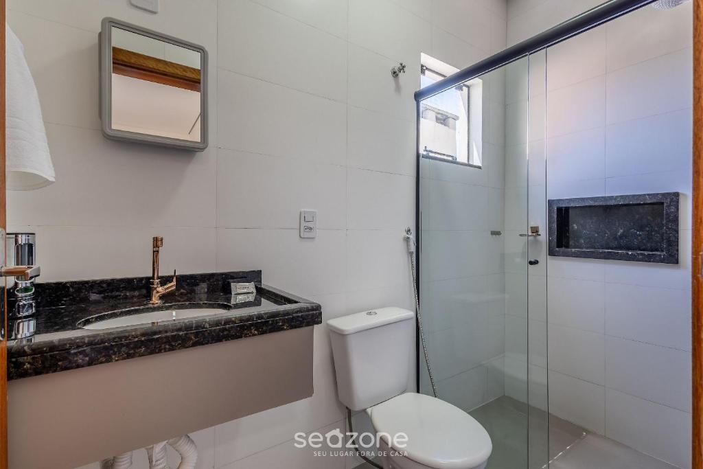 a bathroom with a toilet and a sink and a shower at Aptos completos e com localização privilegiada, 70m do mar - ALOs in Barra Velha