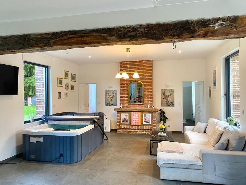Una gran sala de estar con bañera de hidromasaje. en Prestige House & Spa, en Auvilliers