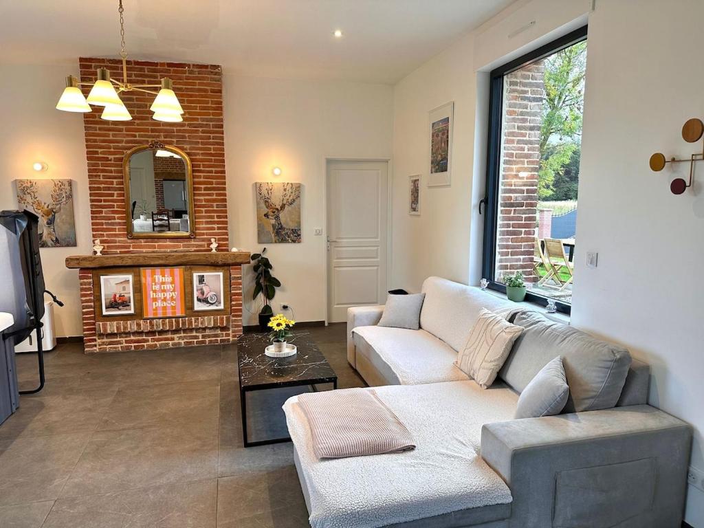 Prestige House & Spa في Auvilliers: غرفة معيشة مع أريكة ومدفأة