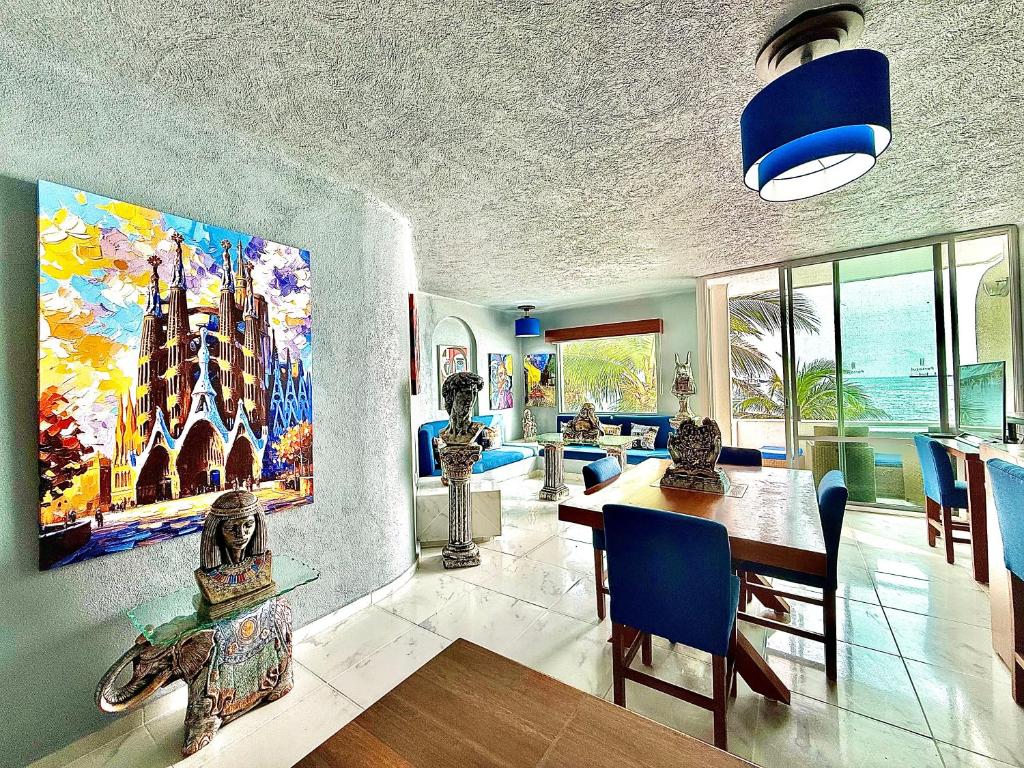 a dining room with a large painting on the wall at Espectacular Apto remodelado, de lujo y a pie de Playa con vista al mar in Manzanillo