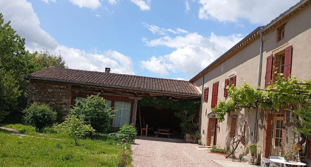 a house with a pathway next to a building at Grand gîte pour 18 personnes dans la campagne tarnaise in Andouque