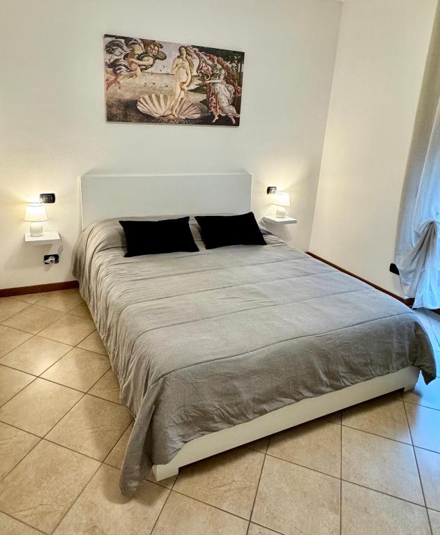 a large bed in a room with two lamps at Top Apartment 2 in Castel d'Azzano