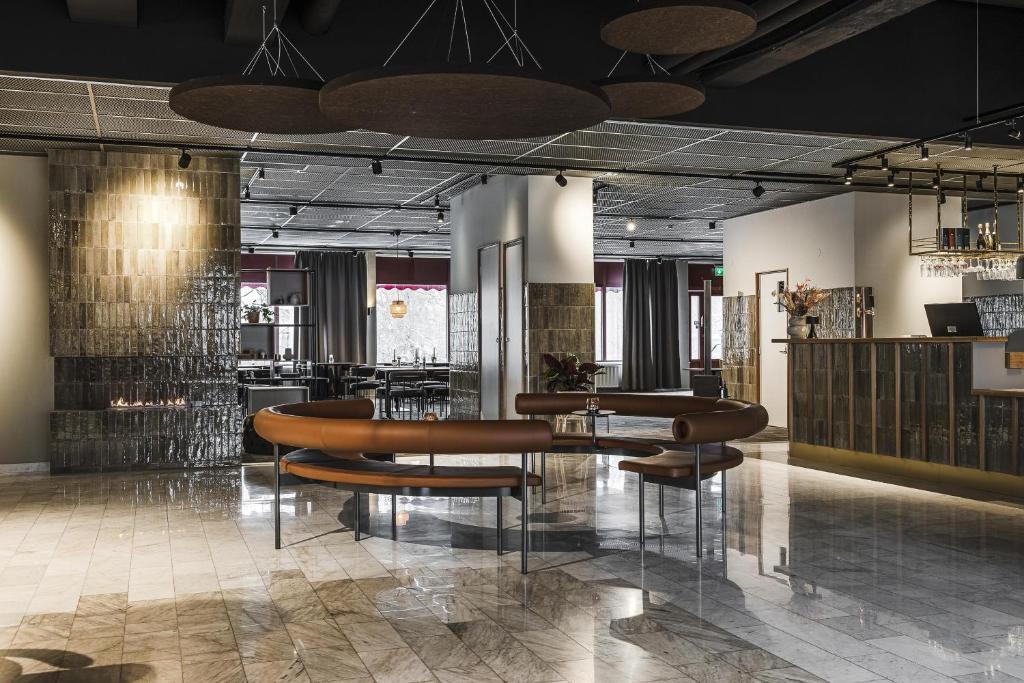 un hall d'entrée avec un groupe de chaises et de tables dans l'établissement Best Western Hotell Kramm, à Kramfors