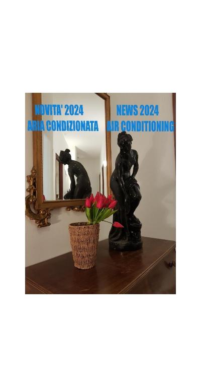 a statue sitting on a table in front of a mirror at Casa Marisa in Albenga