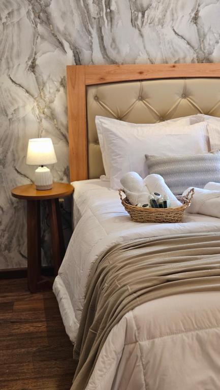 a bed with a basket of towels and a lamp on it at Green Palace Hotel Boutique in Asuncion