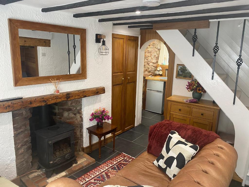 a living room with a couch and a fireplace at Cosy cottage in Torquay