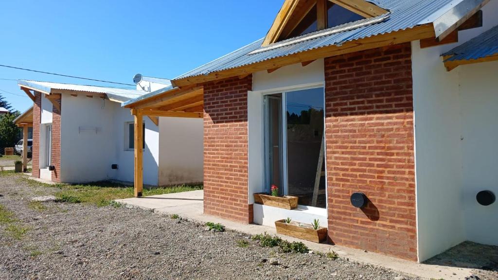 a brick house with a window and a roof at La Chabela 02 in Trevelín