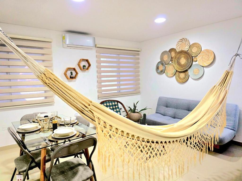 Una hamaca en una sala de estar con una mesa y un sofá. en KA'I KASHI - Modern Apartment close to beach, en Ríohacha