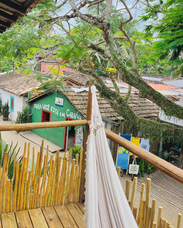 a hammock on a wooden fence in front of a building at Pousada Tamuré in Caraíva