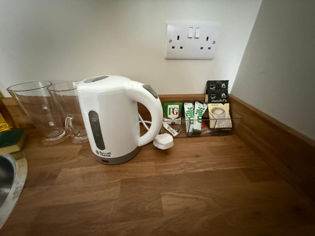 a coffee maker sitting on top of a wooden floor at 30C The Luxury Studios near Arsenal and Central London in London
