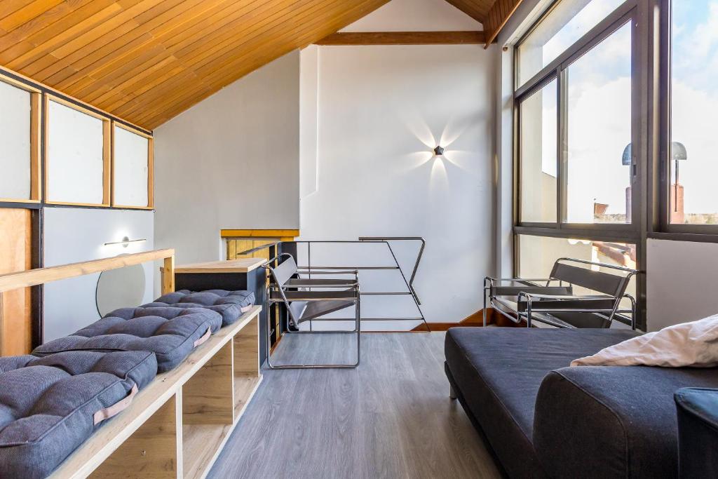 une chambre avec canapés et fenêtres dans un bâtiment dans l'établissement BaruHaus triplex piscina y parking, à Villamañán