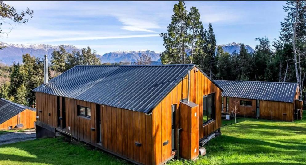 a wooden house with a black roof at Henko 1 in Villa La Angostura