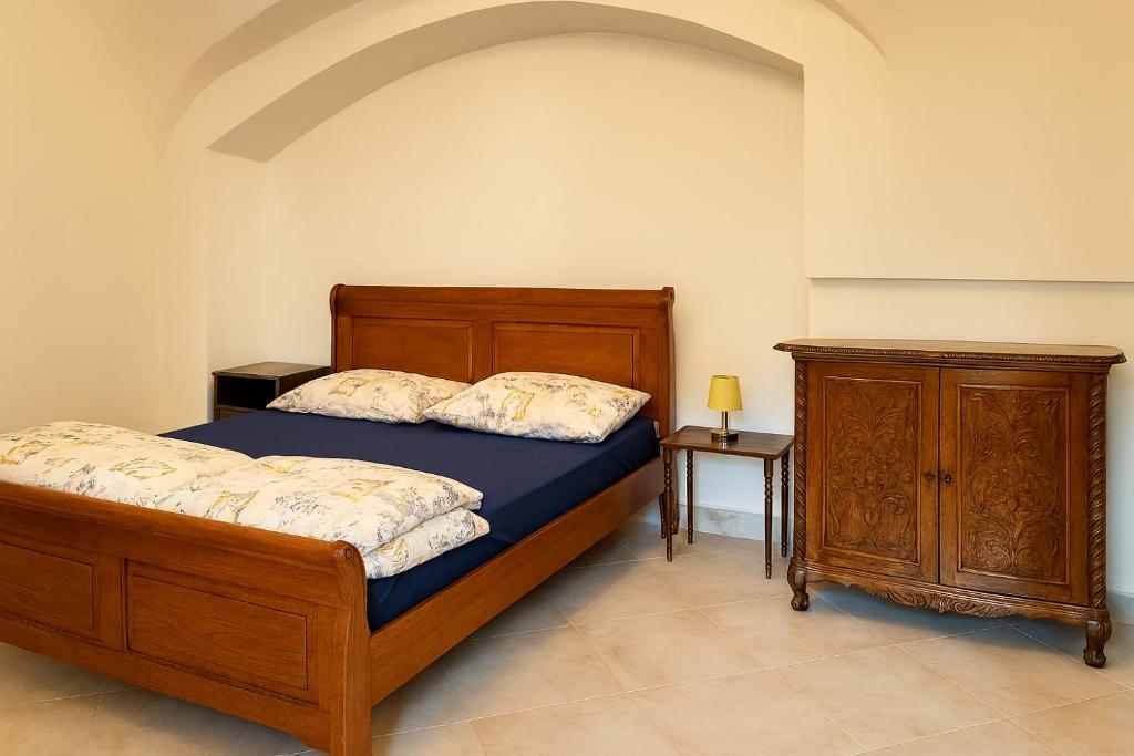 a bedroom with a wooden bed and a wooden dresser at Great location in the centre of Kosice in Košice