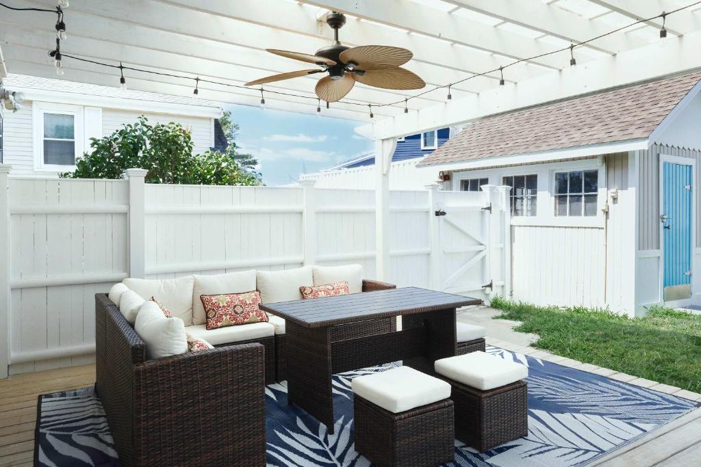 a patio with a couch and a table and a ceiling fan at Stay at East Gloucester in Gloucester