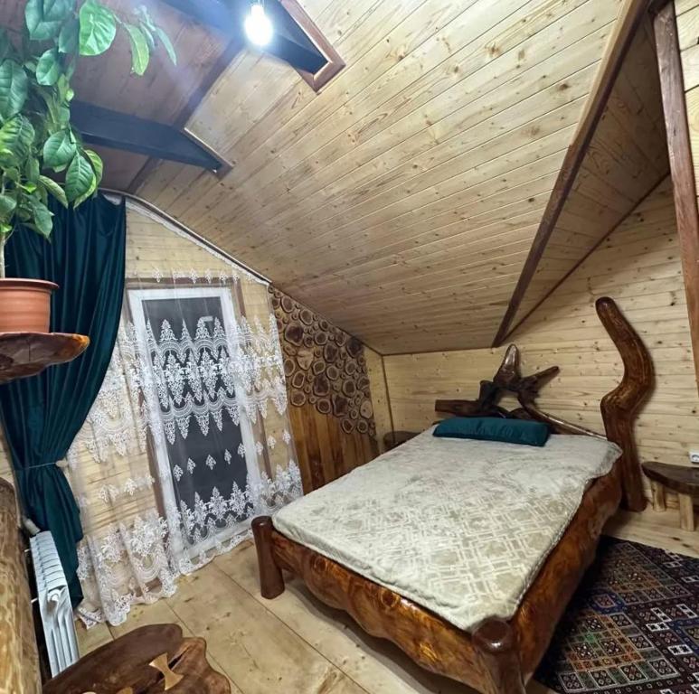 een slaapkamer met een bed in een blokhut bij Корінь in Krasnoilov