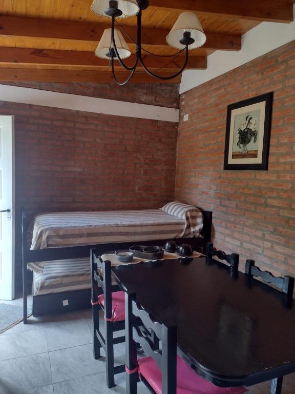 a room with two beds and a table in it at Casita traslasierras in San Lorenzo