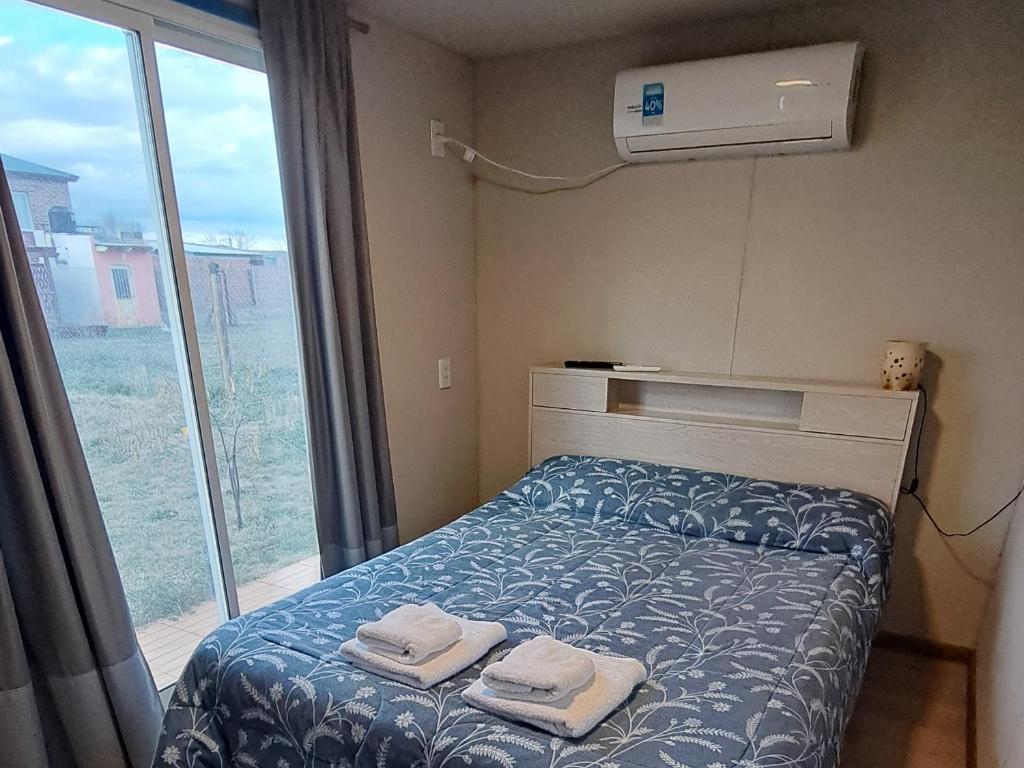 a bedroom with a bed with two towels on it at LEKU Departamentos in General Acha