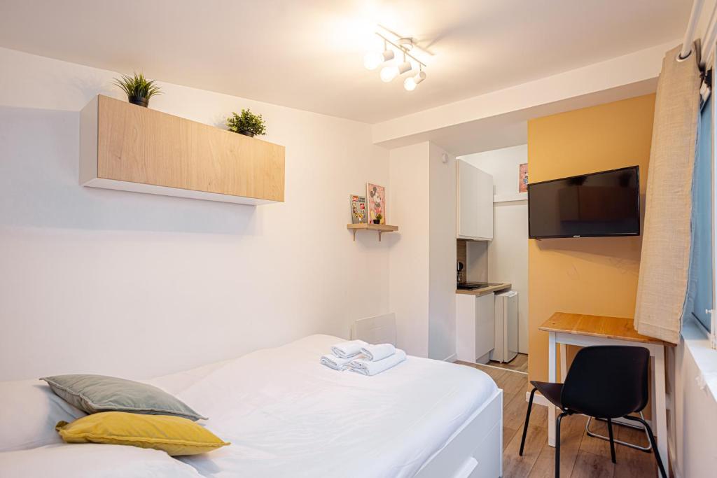 a small bedroom with a bed and a tv at Studio GOOD VIBES - Wifi - Cosy - Hyper-centre in Orléans