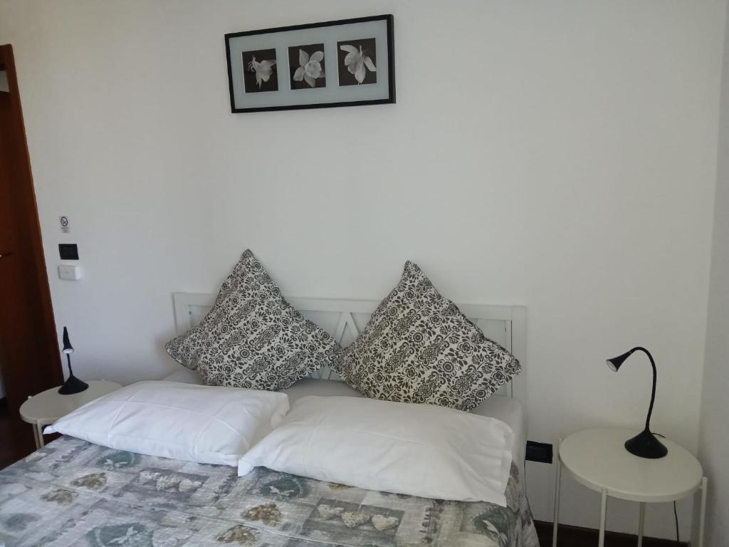 a bedroom with a bed with pillows on it at Appartamentino uso esclusivo in Padova