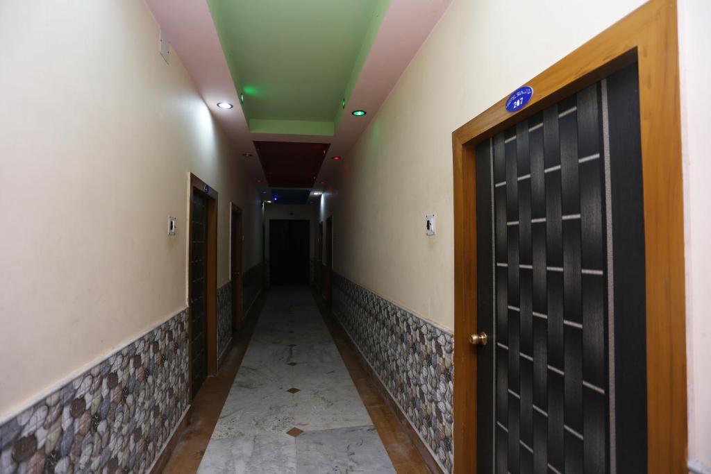un couloir avec une porte noire et un corridorngthngthngthngthngth dans l'établissement Hotel O Sanjog, à Bakkhali