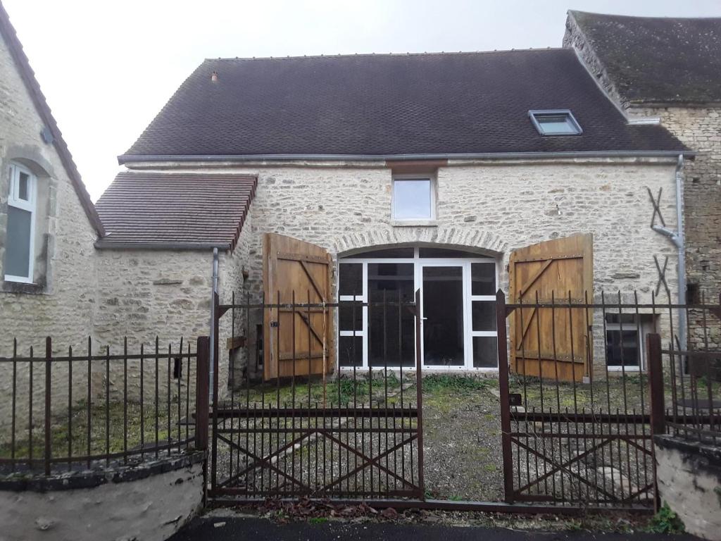 a brick house with a gate with wooden doors at Gite du relais in Parques
