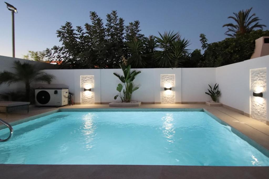 une grande piscine avec des lumières sur un mur blanc dans l'établissement Casa Olivia with pool heating fee, à Torrevieja